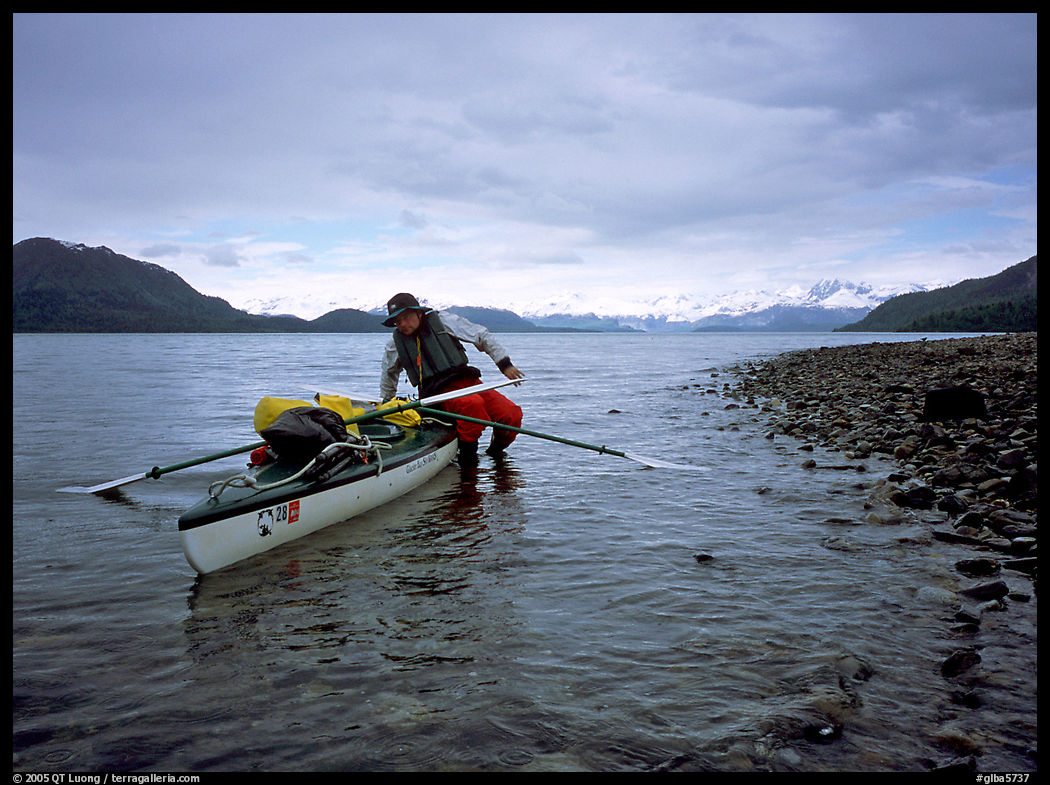 Kayaker getting into the kayak,  Muir Inlet. Glacier Bay National Park, Alaska