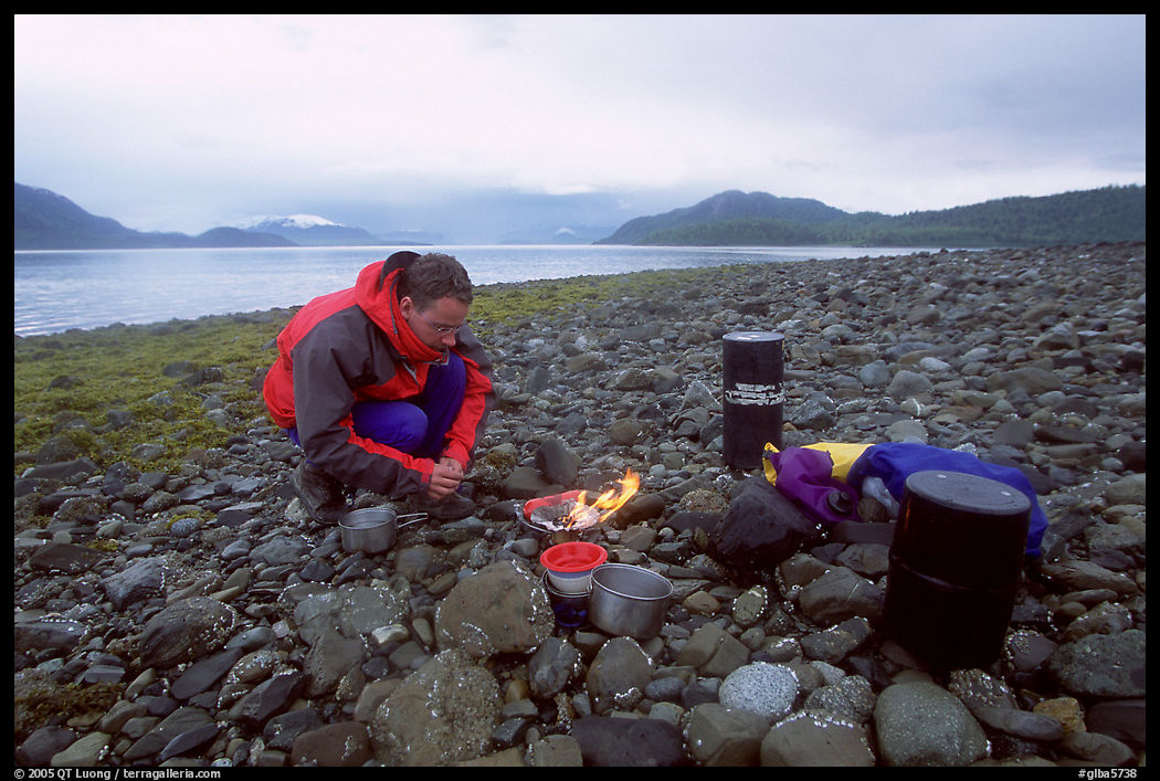 Kayaker firing up the stove,  Muir Inlet. Glacier Bay National Park, Alaska