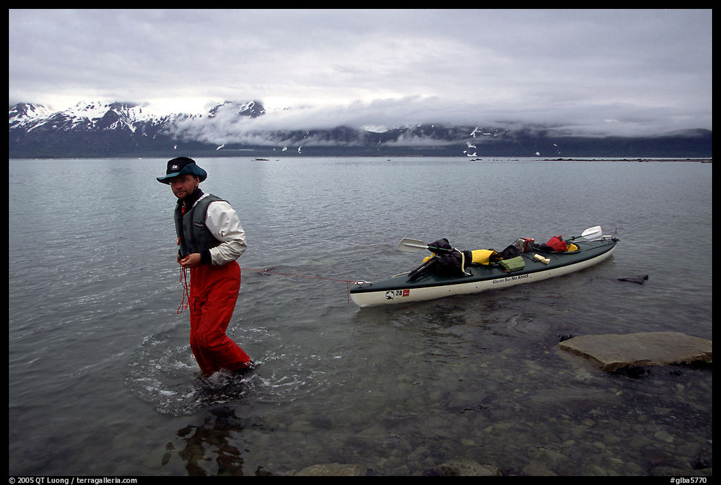 Kayaker towing kayak, East arm. Glacier Bay National Park, Alaska
