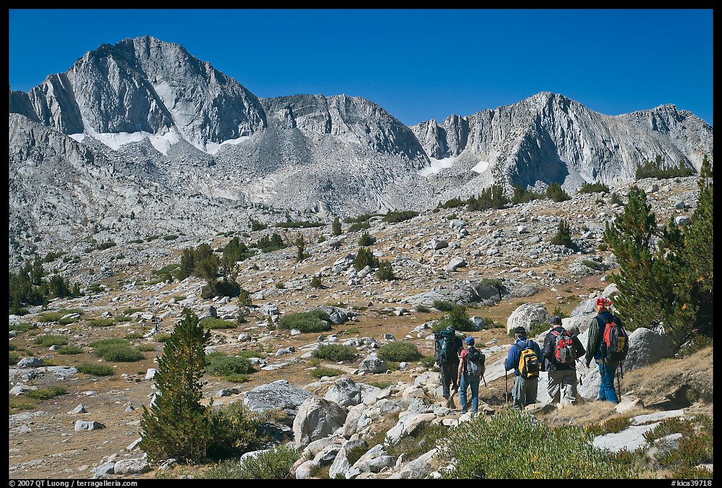 Hikers on alpine terrain and Mt Giraud range, Dusy Basin. Kings Canyon National Park, California