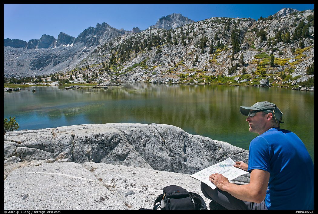 Hiker with map near lake, lower Dusy Basin. Kings Canyon National Park, California