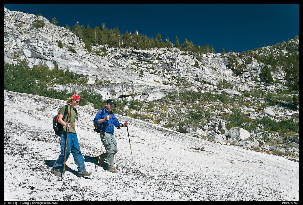 Father and son hiking on granite slab, Le Conte Canyon. Kings Canyon National Park, California