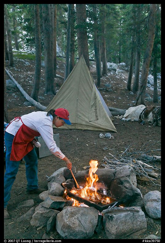 Woman preparing food at campfire, Le Conte Canyon. Kings Canyon National Park, California