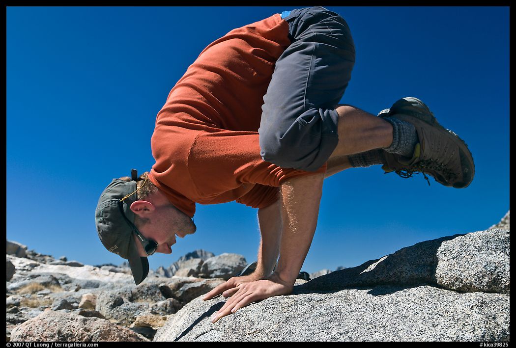 Hiker balancing on hands on rock, Bishop Pass. Kings Canyon National Park, California