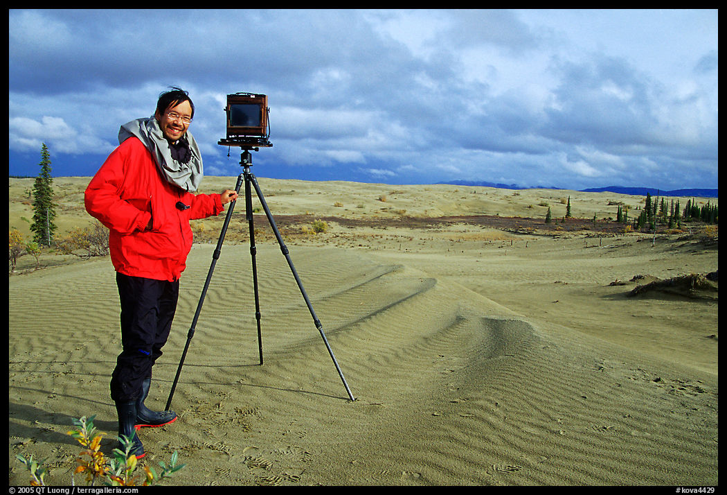 Large format photographer with camera on Kobuk Dunes. Kobuk Valley National Park, Alaska