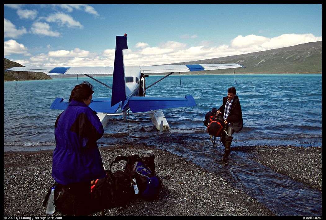 Pilot unloading a backpack from the floatplane on Lake Turquoise. Lake Clark National Park, Alaska