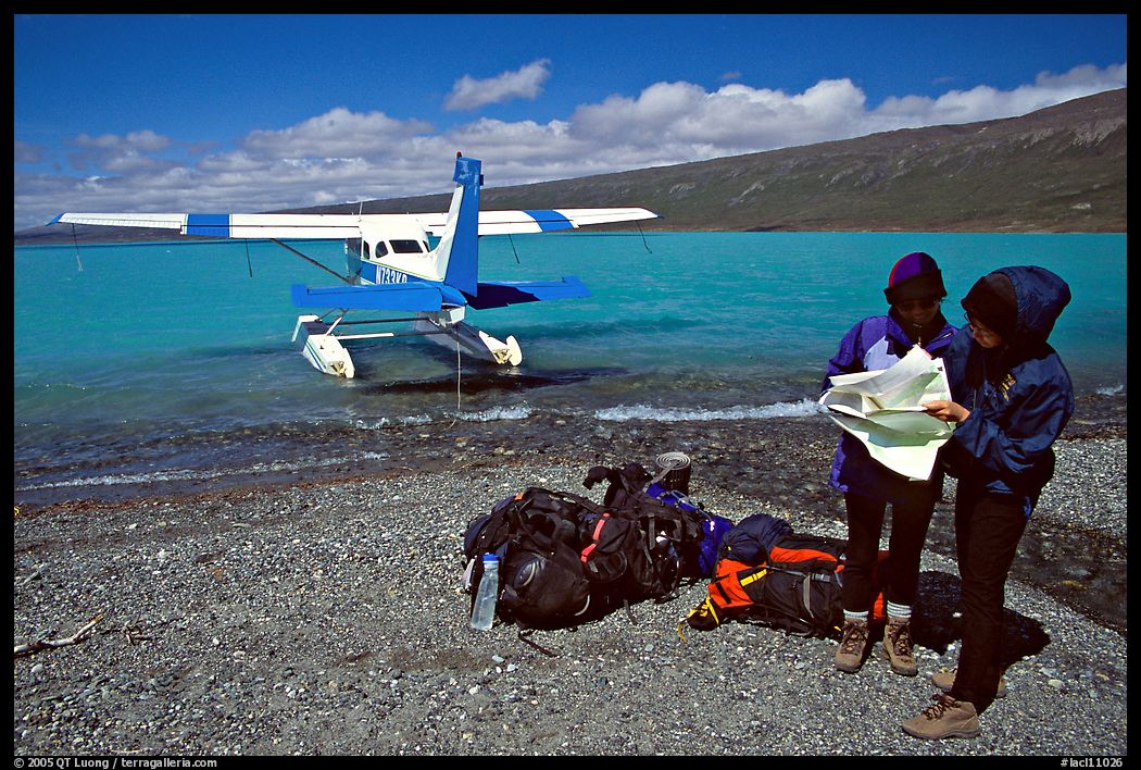 Backpackers dropped off by floatplane on Lake Turquoise orient themselves on the map. Lake Clark National Park, Alaska
