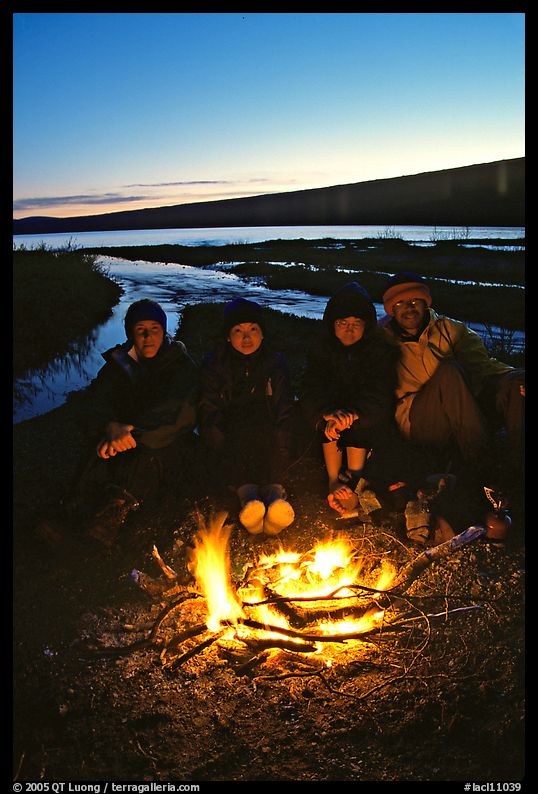 Campers warming toes in campfire next to Turquoise Lake. Lake Clark National Park, Alaska