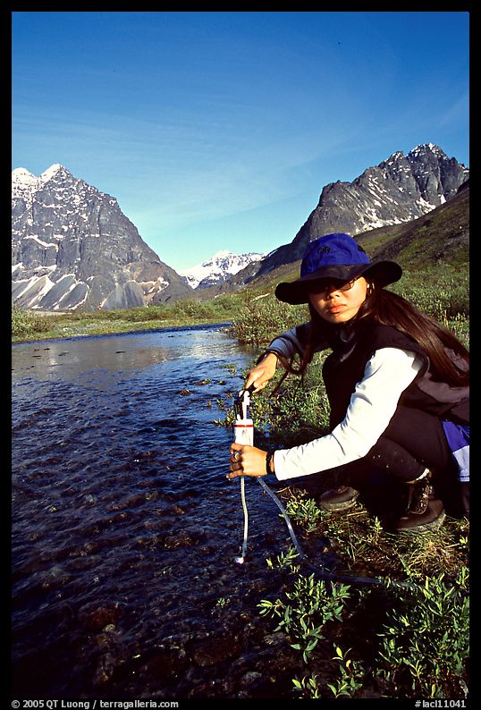 Woman filtering water from a stream. Lake Clark National Park, Alaska