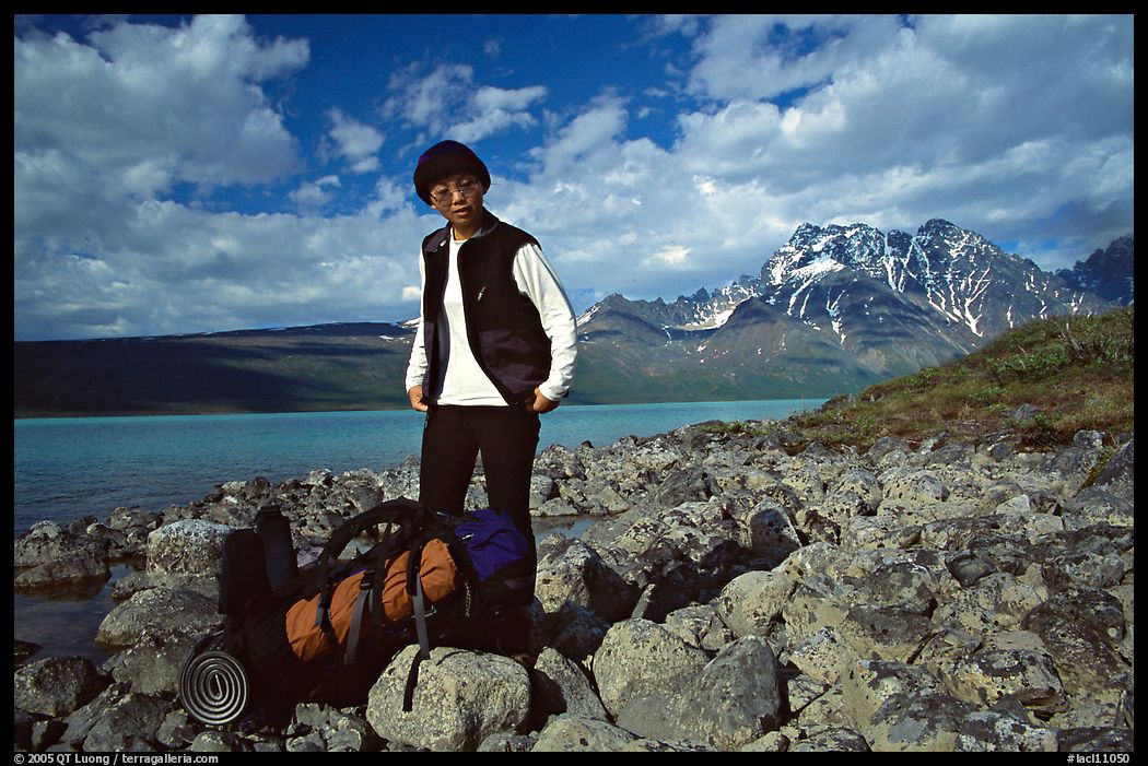 Backpacker pausing on the shore of Turquoise Lake. Lake Clark National Park, Alaska