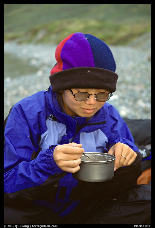 Backpacker eating camp food. Lake Clark National Park, Alaska