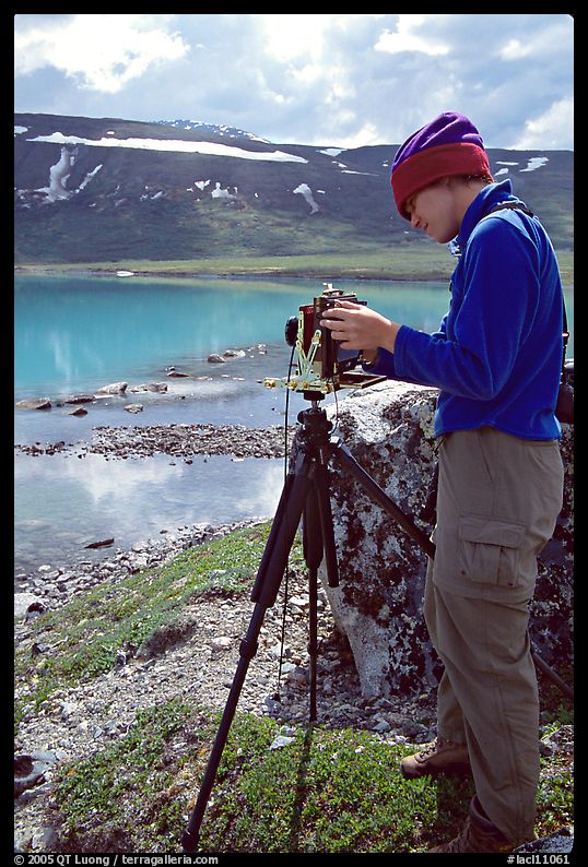 Large format photographer with camera on the shores of Turquoise Lake. Lake Clark National Park, Alaska