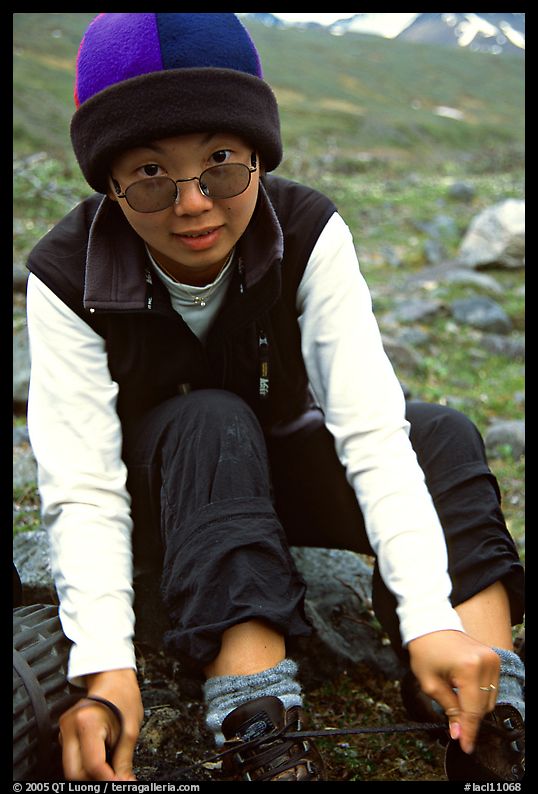 Woman backpacker putting back boots after a stream crossing. Lake Clark National Park, Alaska