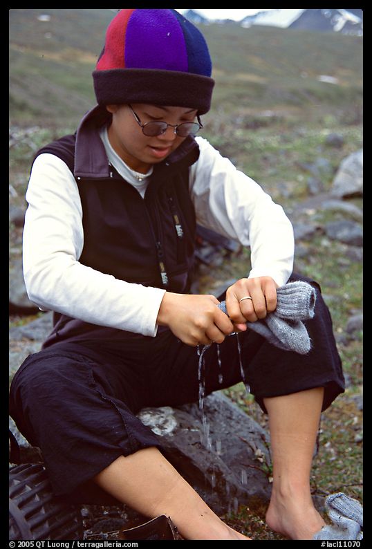 Woman backpacker drying socks after a stream crossing. Lake Clark National Park, Alaska
