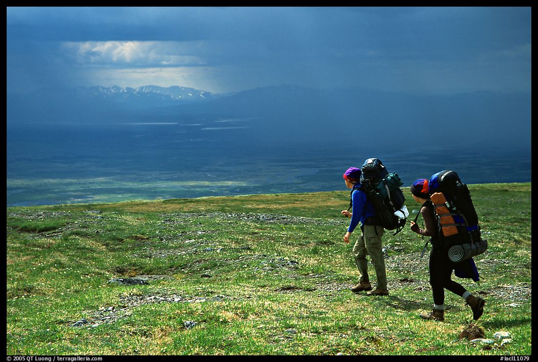 Two backpackers arrive at a ridge as a storm clears. Lake Clark National Park, Alaska