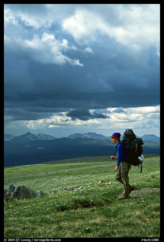 Backpacker seen from the side walking fast in the tundra. Lake Clark National Park, Alaska