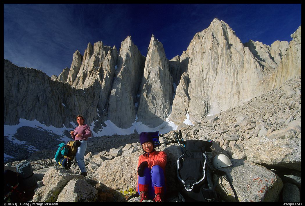 Man and woman pausing with backpacks below the East face of Mt Whitney. Sequoia National Park, California