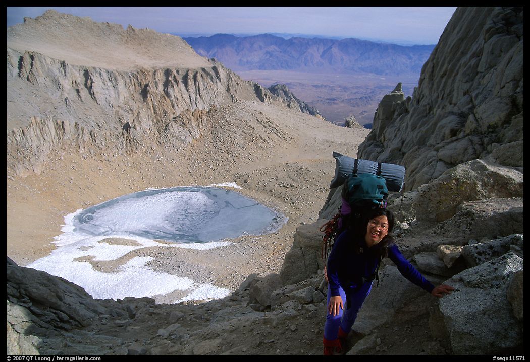 Woman with backpack pausing on steep terrain above Iceberg Lake. Sequoia National Park, California