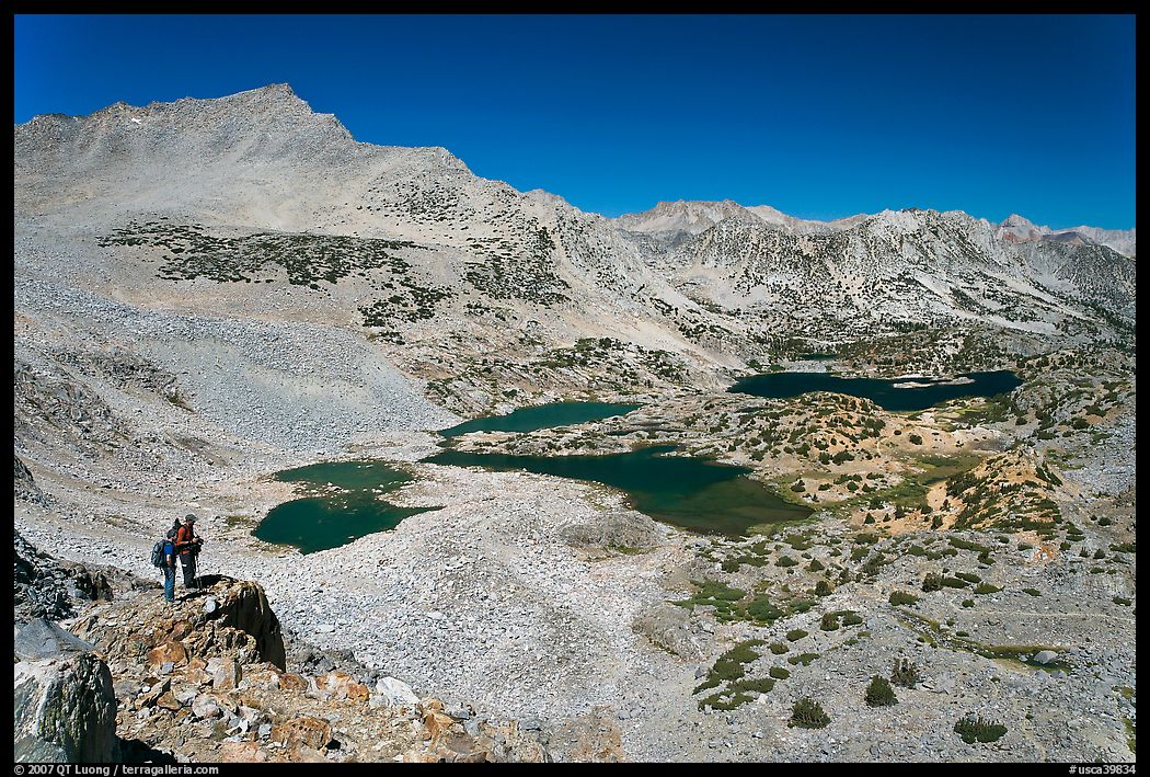 Hikers looking at view  above Saddlebag Lakes, John Muir Wilderness. Kings Canyon National Park, California