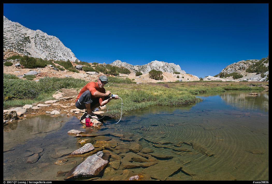 Man filtering water from stream, John Muir Wilderness. Kings Canyon National Park, California