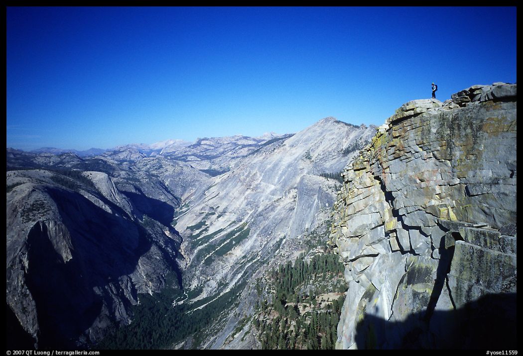Hiker standing on top of Half-Dome, overlooking Tenaya Canyon. Yosemite National Park, California