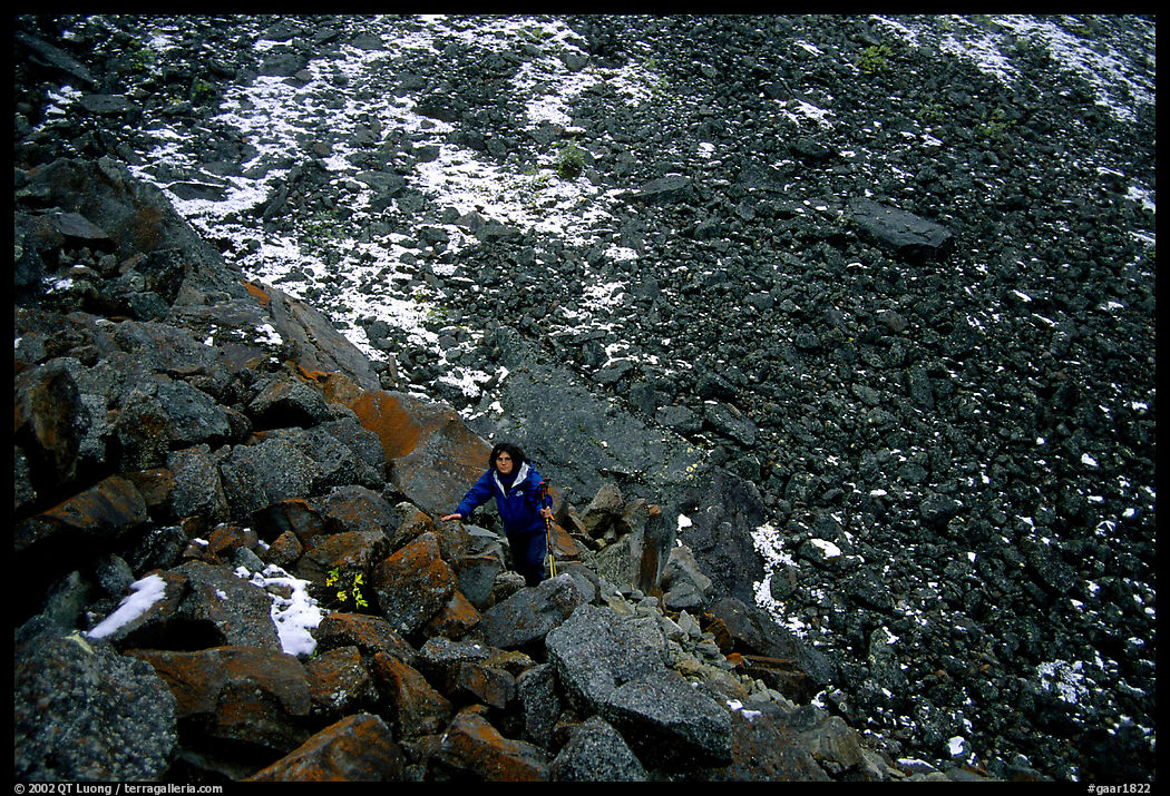 Backpacker in boulder field at the base of the Arrigetch Peaks. Gates of the Arctic National Park, Alaska