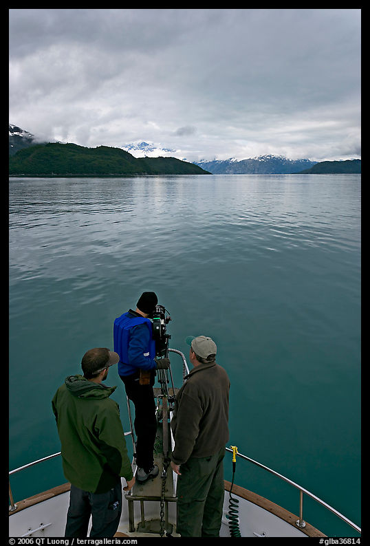 Film crew working on the bow of a small boat. Glacier Bay National Park, Alaska, USA.