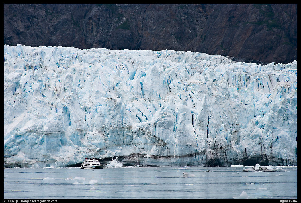 Small tour boat dwarfed by Margerie Glacier. Glacier Bay National Park, Alaska, USA.
