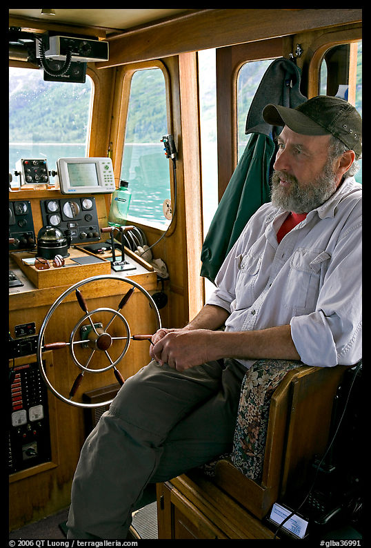 Captain sitting at the wheel. Glacier Bay National Park, Alaska, USA.