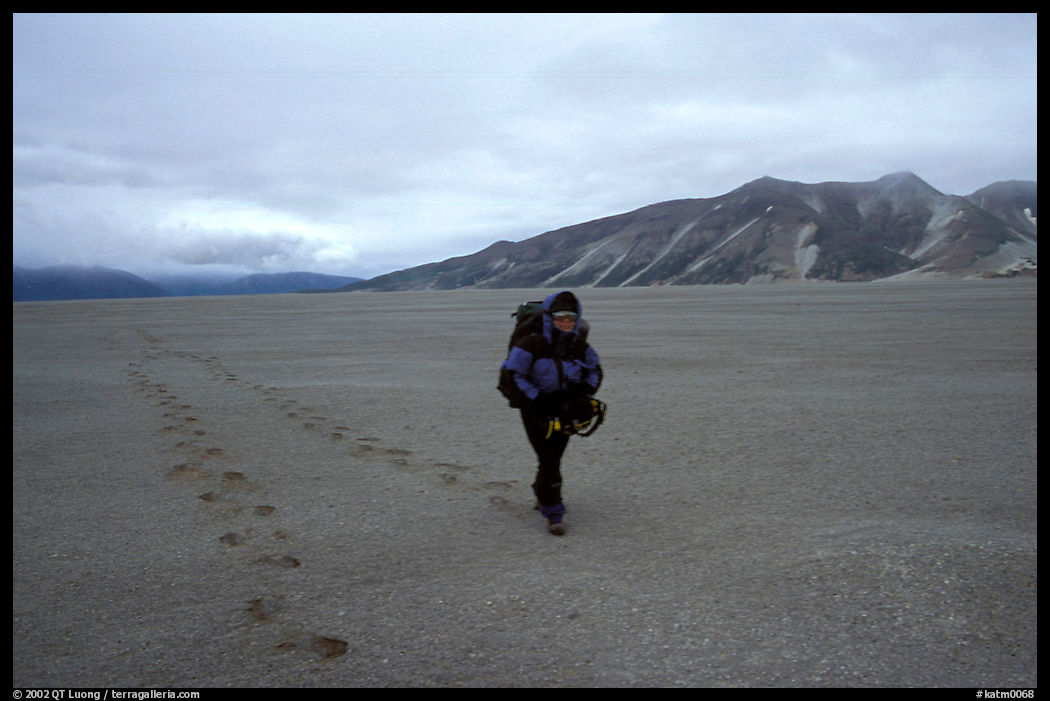 Backpacker hikes in sand-like ash, Valley of Ten Thousand smokes. Katmai National Park, Alaska