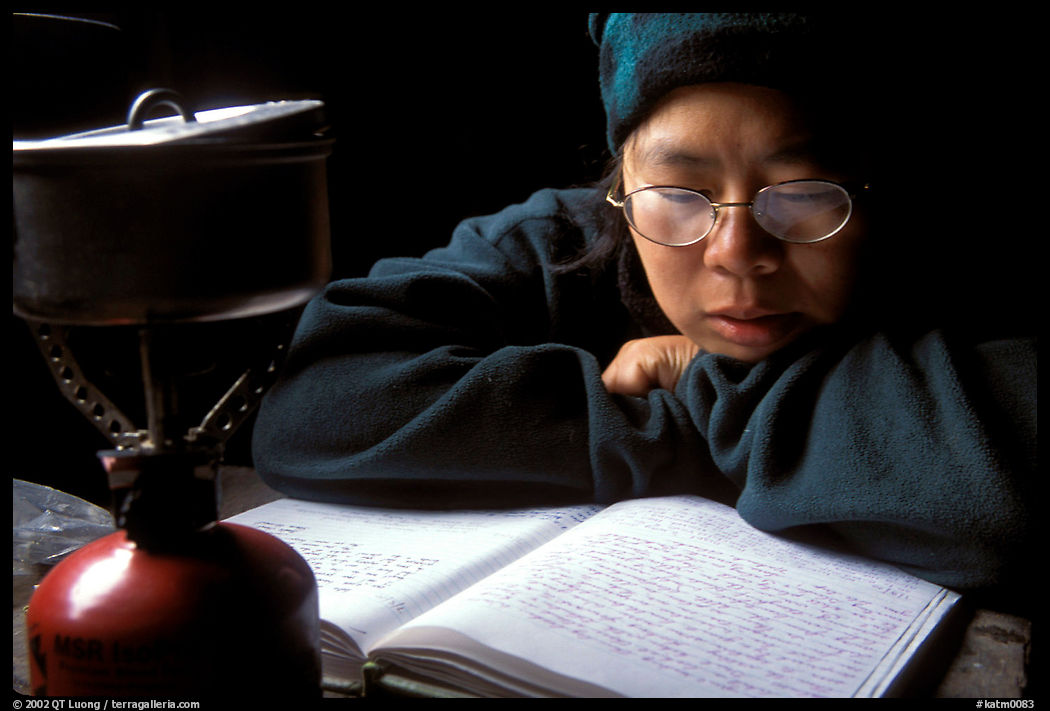 Backpacker reads visitor log in abandonned geological survey cabin, Valley of Ten Thousand smokes. Katmai National Park, Alaska