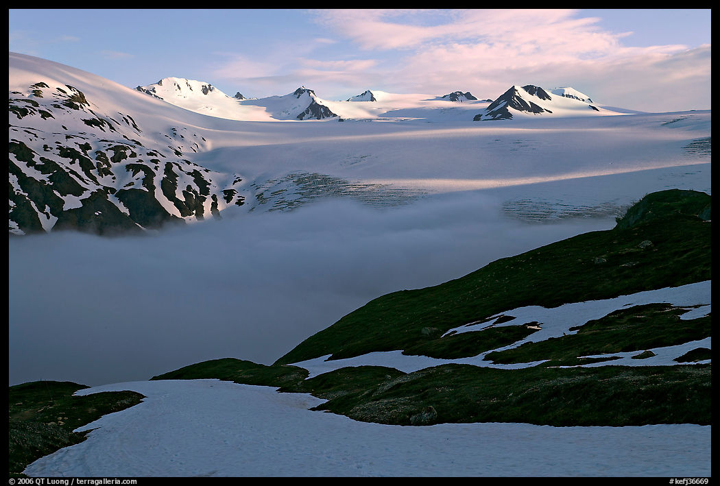 Low clouds, partly melted snow cover, and mountains. Kenai Fjords  National Park, Alaska, USA.