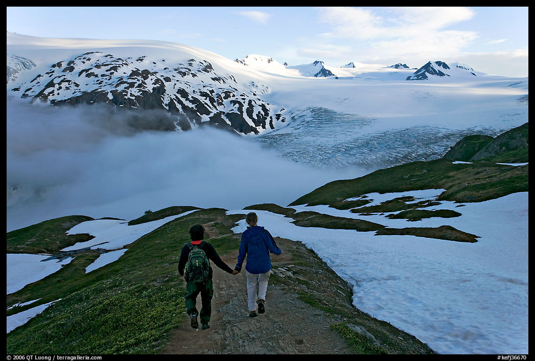 Couple hiking down Harding Icefied trail, late afternoon. Kenai Fjords  National Park, Alaska, USA.