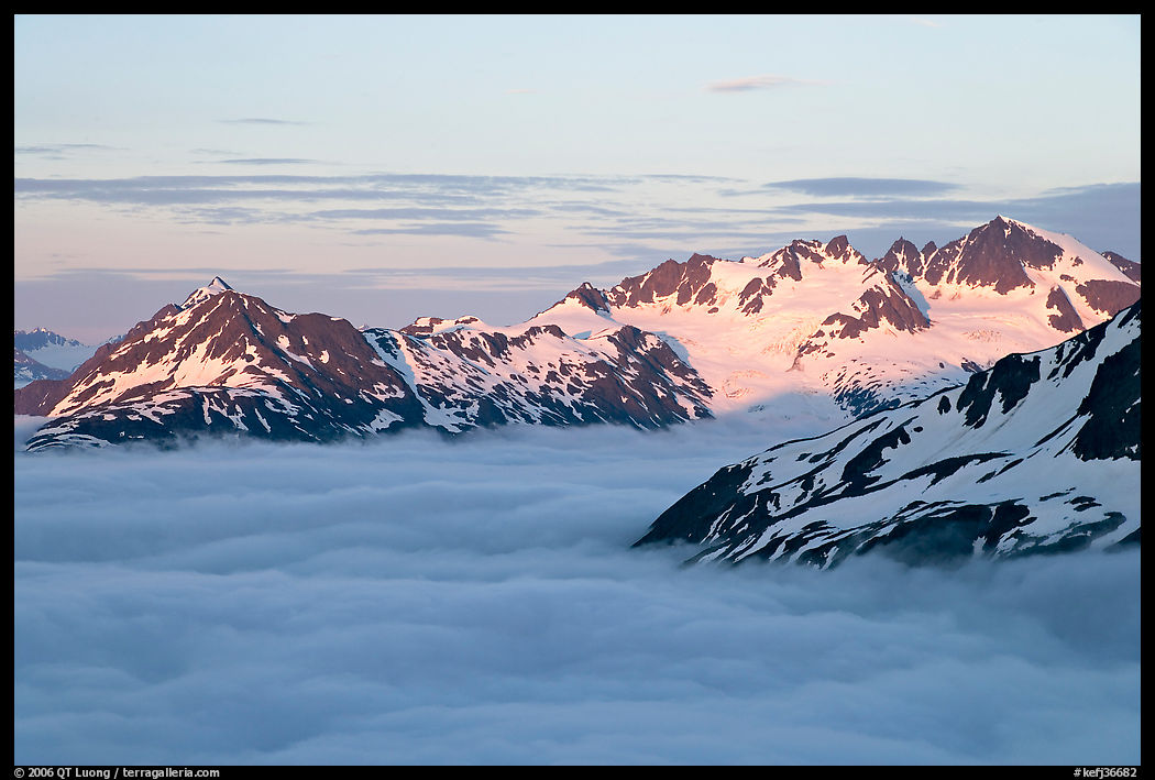 Midnight sunset on peaks above clouds. Kenai Fjords  National Park, Alaska, USA.