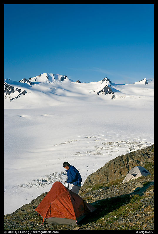 Camper exiting tent above the Harding ice field. Kenai Fjords  National Park, Alaska, USA.