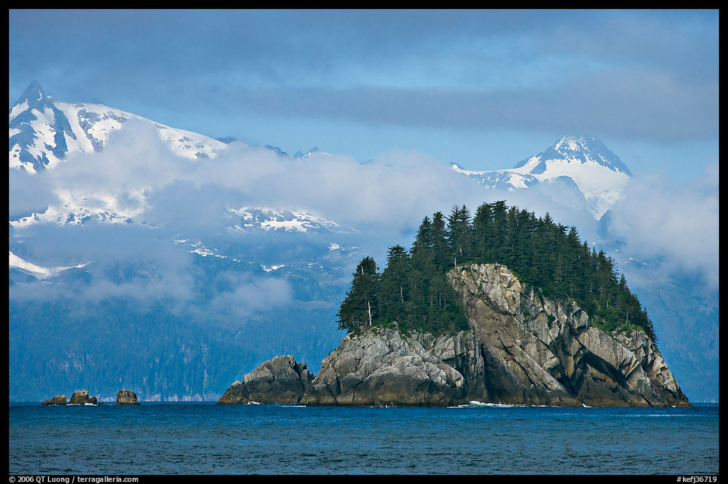 Rocky islet and snowy peaks, Aialik Bay. Kenai Fjords  National Park, Alaska, USA.
