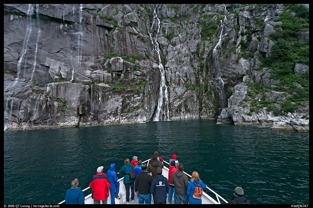 Waterfall viewing from deck of tour boat, Cataract Cove. Kenai Fjords  National Park, Alaska, USA.