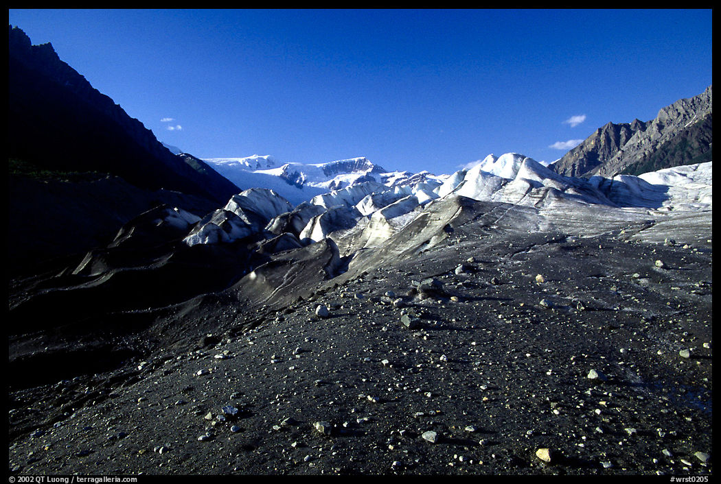 Morainic debris on Root glacier with Wrangell mountains in the background, late afternoon. Wrangell-St Elias National Park