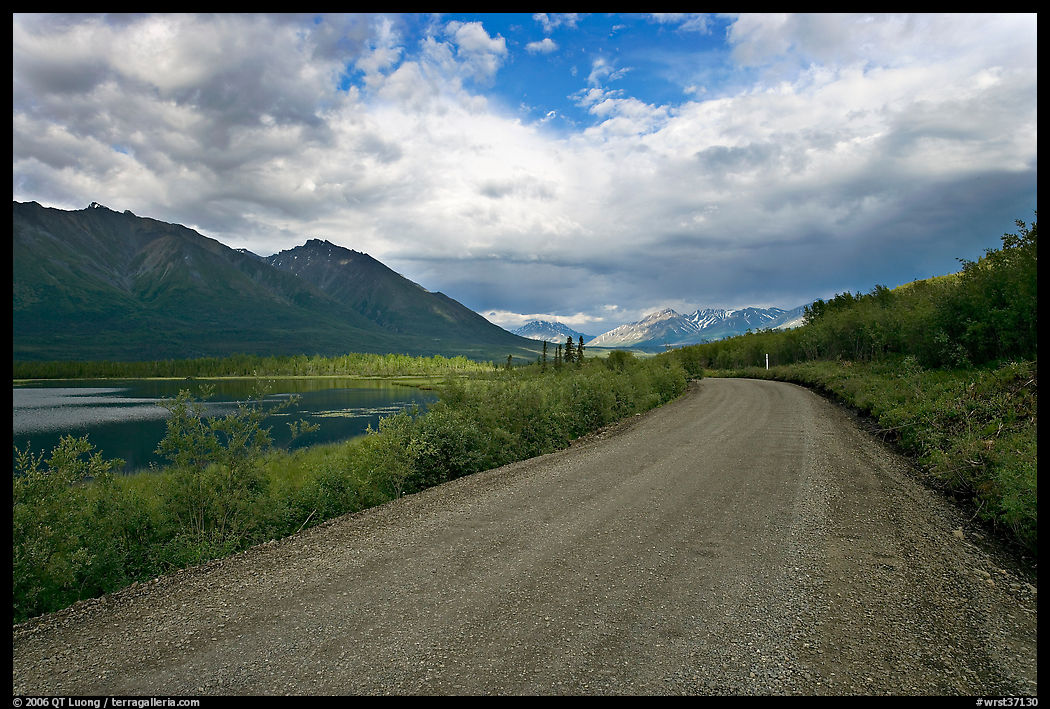 Unpaved McCarthy Road next to lake. Wrangell-St Elias National Park, Alaska, USA.