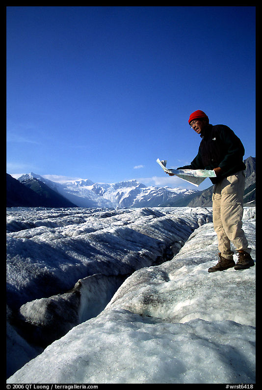 Hiker checks map on Root Glacier. Wrangell-St Elias National Park, Alaska, USA.