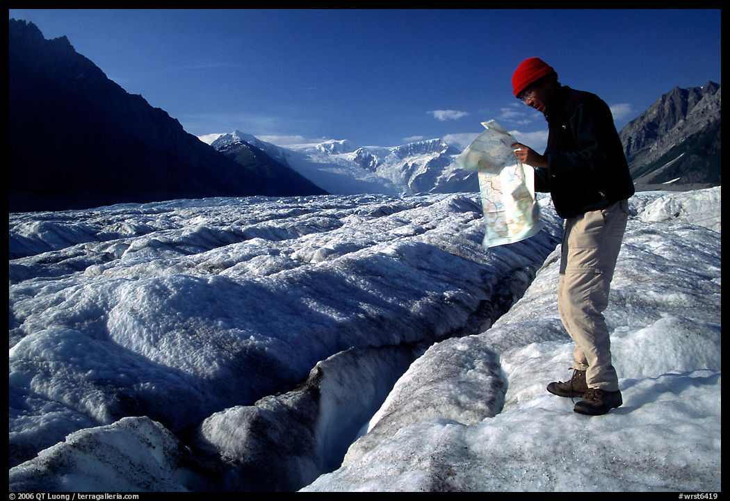 Hiker checks map on Root Glacier. Wrangell-St Elias National Park, Alaska, USA.