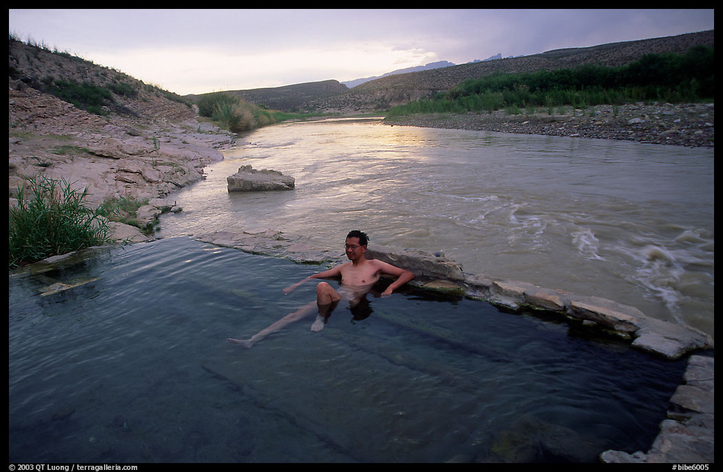 Visitor relaxes in hot springs next to Rio Grande. Big Bend National Park, Texas, USA.