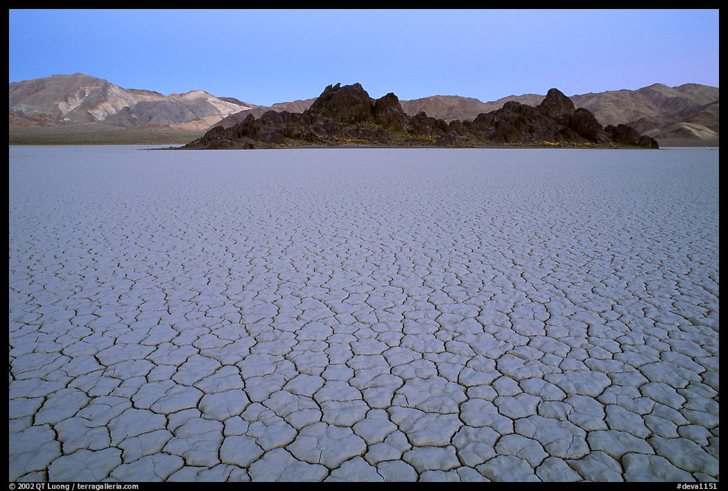 Tiles in cracked mud and Grand Stand, Racetrack playa, dusk. Death Valley National Park, California, USA.