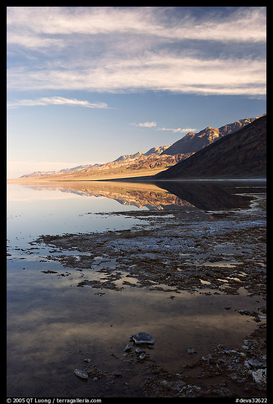 Black mountain reflections in flooded Badwater basin, early morning. Death Valley National Park, California, USA.