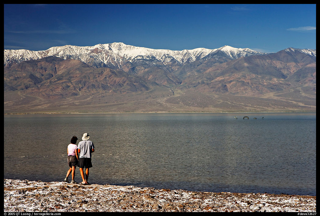 Couple watches the dragon in ephemeral lake. Death Valley National Park, California, USA.