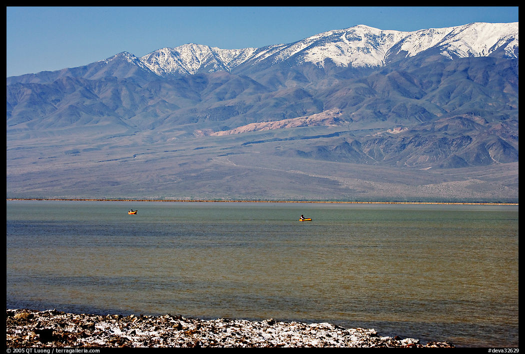 Kayakers in ephemeral Manly lake, and Panamint Range. Death Valley National Park, California, USA.