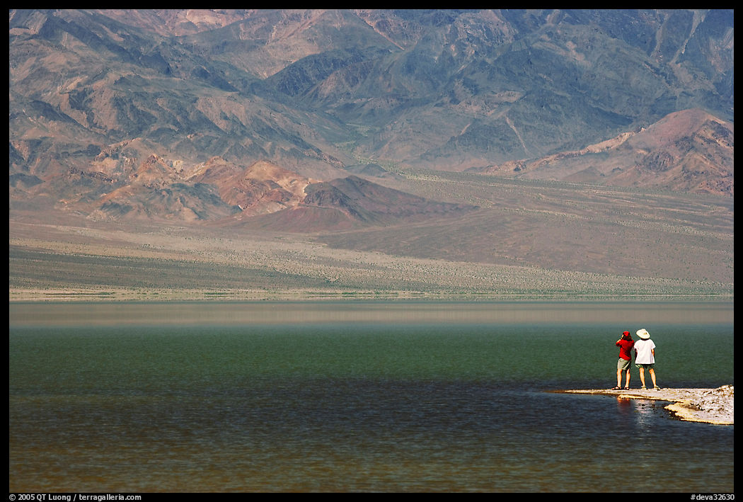 Two visitors on shore of rare lake on the floor of the Valley. Death Valley National Park, California, USA.