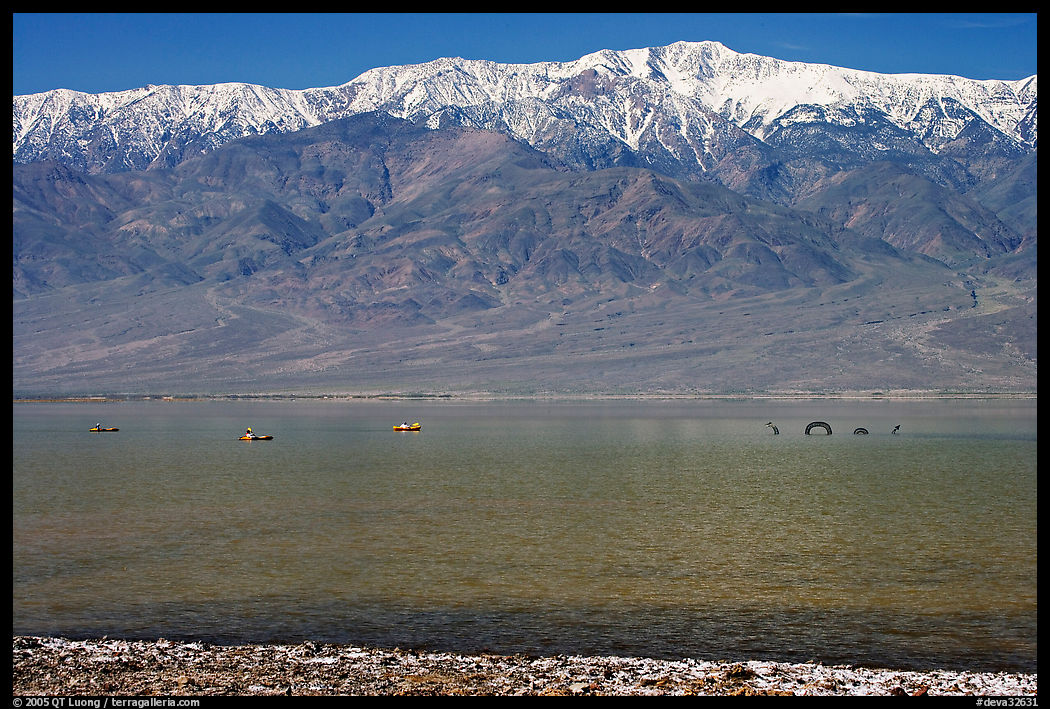 Kayakers padding towards the Loch Ness Monster in Manly Lake, below Telescope Peak. Death Valley National Park, California, USA.