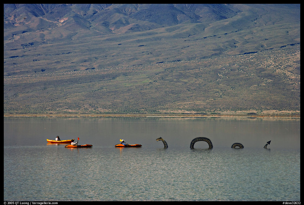 Kayakers approaching the dragon in the rare Manly Lake. Death Valley National Park, California, USA.