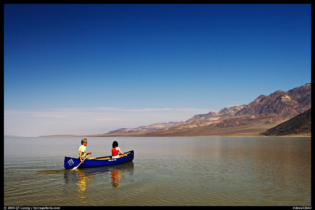 Canoeing on the ephemerald Manly Lake with Black Mountains in the background. Death Valley National Park, California, USA.